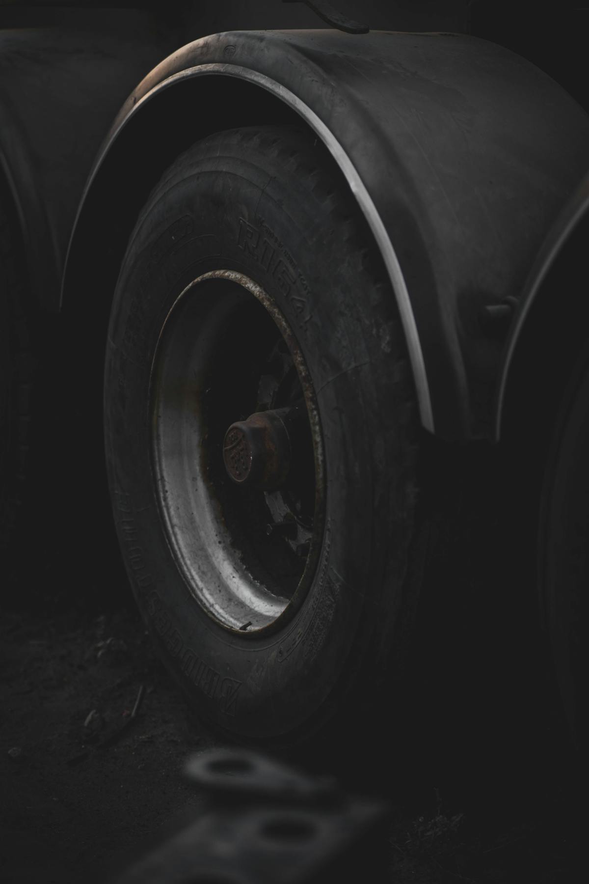Close-up of a car tyre with a small nail causing a slow puncture