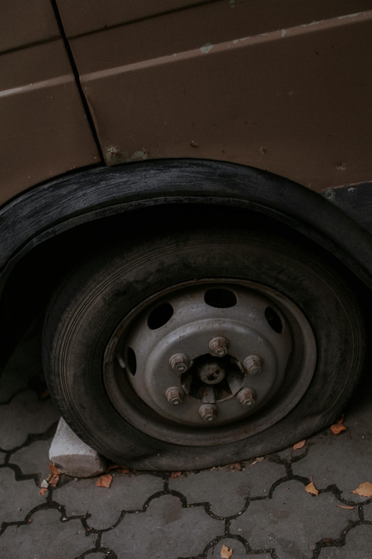 A flat car tyre at the roadside with no spare wheel available