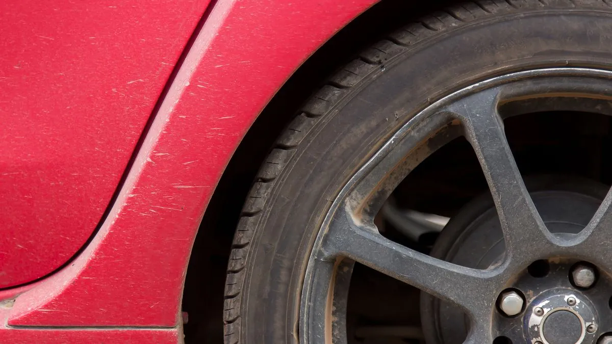 A pair of new tyres being fitted to the rear axle of a car