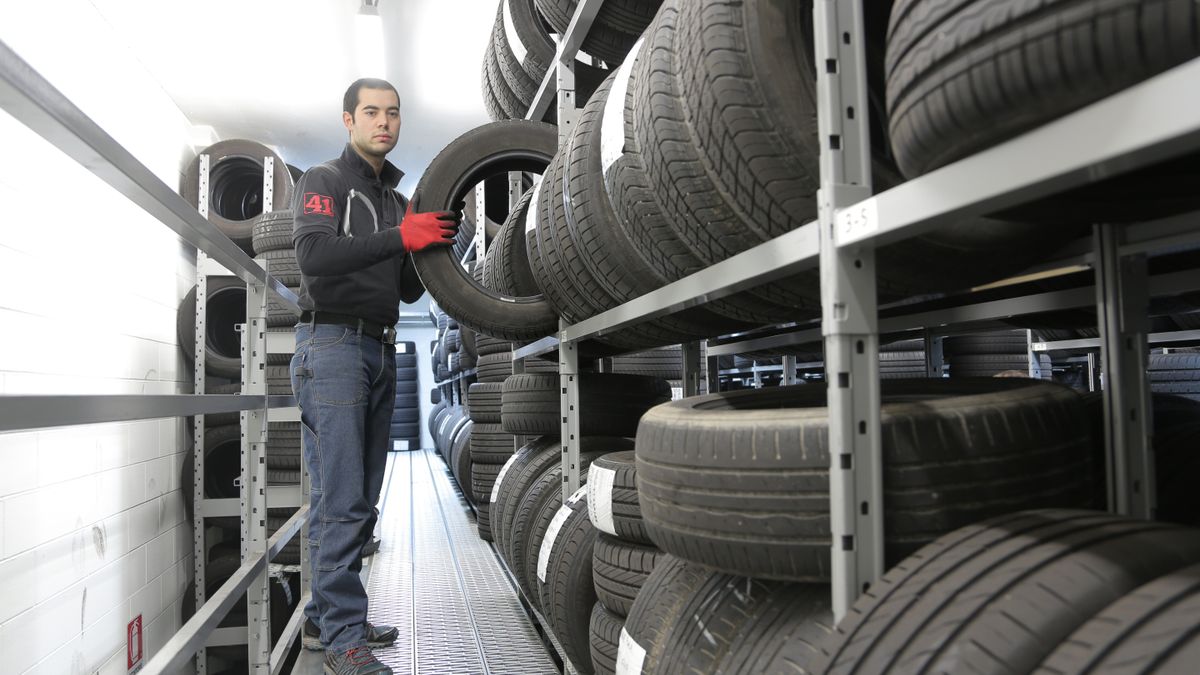 A car being fitted with new tyres in an office car park