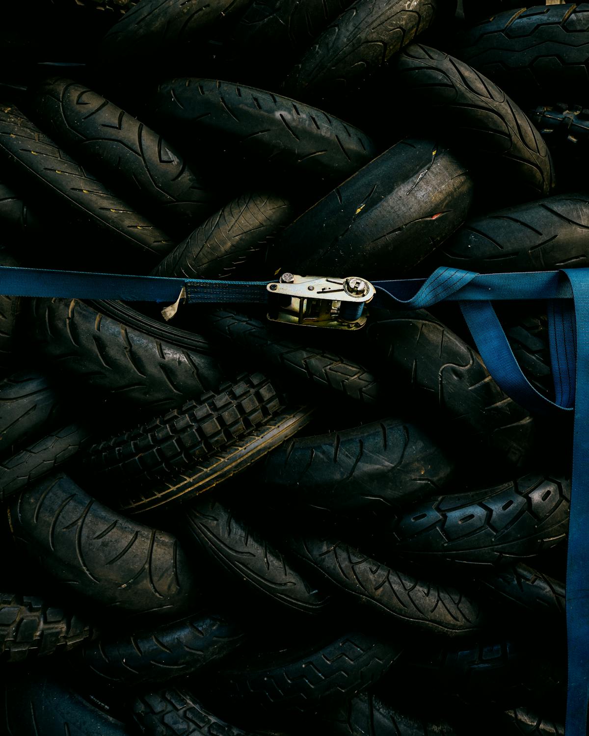 A stack of worn used car tyres ready for replacement and recycling