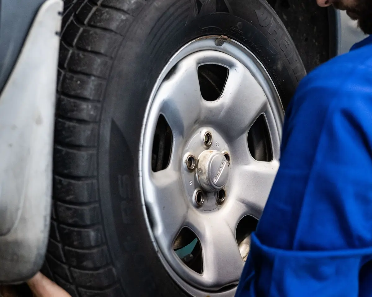 Technician lifting a wheel onto a hub