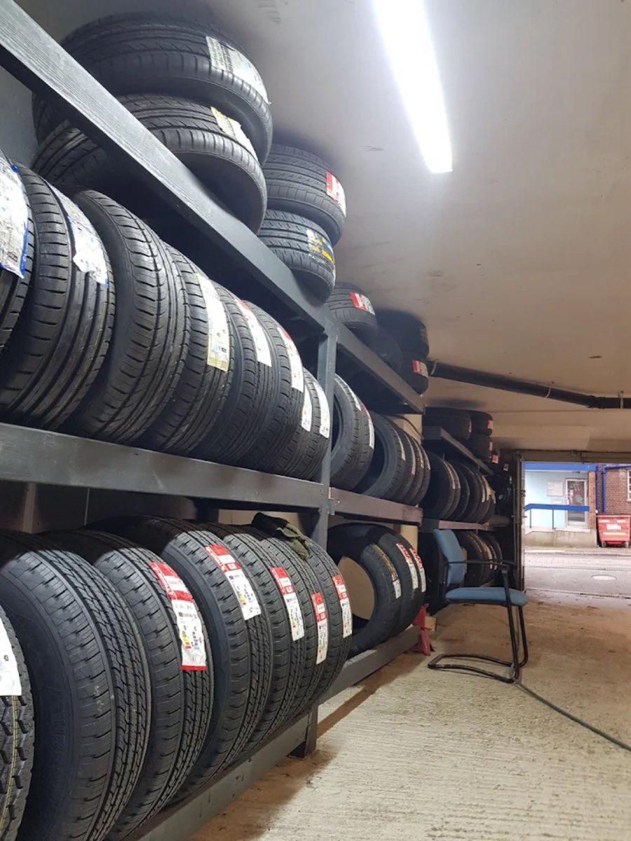 Fitter mounting a new wheel onto a car